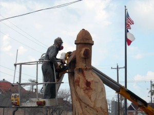 James Phillips saws away as he sculpts a fire hydrant out of an oak tree that died as a result of Hurricane Ike. This sculpture is located next to City Hall in Galveston.