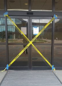 Sliding glass doors to Bayou Building from Alumni Plaza in disrepair