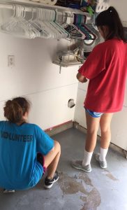 PHOTO: Liliana Gonzalez and Rachel Hill helping cut into the walls using the chalk line. Photo by The Signal reporter, Mariana Gonzalez.