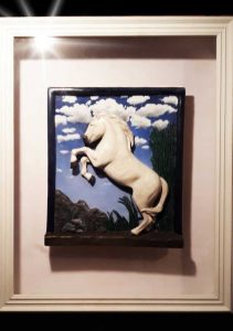 Art piece by Dale Reed featured at the exhibit. Image of a white horse rearing. Photo courtesy of Dale Reed.