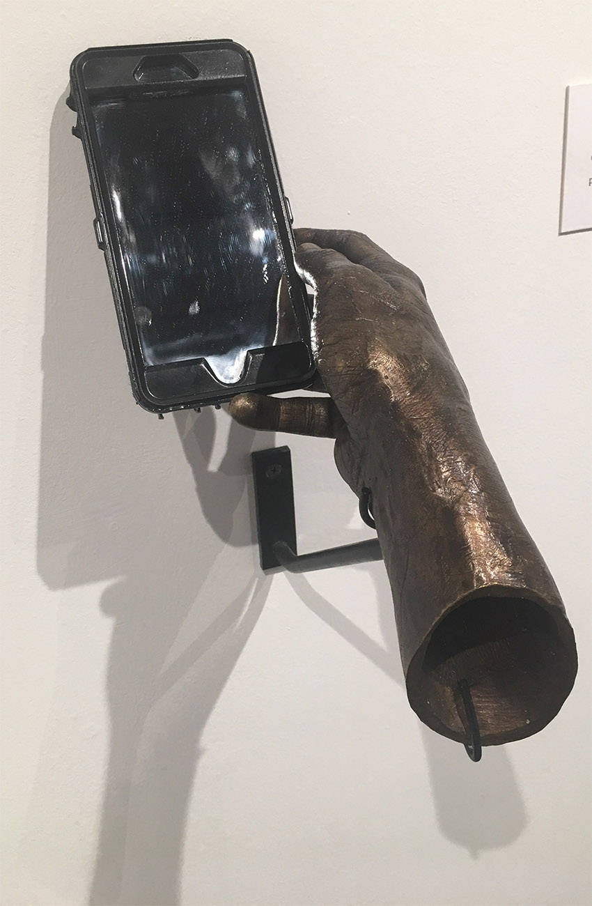 PHOTO: Austin Stout's sculpture "Self Portrait" is a bronze hand holding a mirror made to look like a phone. Foundry is a course taken by many studio concentration students within the Art and Design BFA program. Photo by The Signal Online Editor Alyssa Shotwell.
