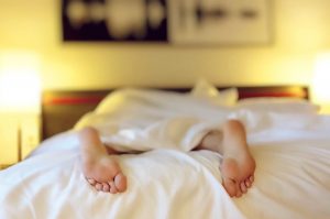 PHOTO: To stay healthy, it is recommended that adults have 7-9 hours of sleep each night. Good sleep contributes to mental and physical health. Photo of person laying down under the sheets. Photo courtesy of Pixabay.