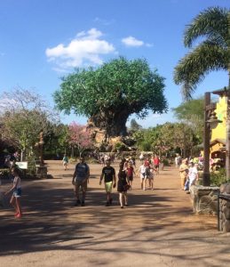 PHOTO: The tree of life standing tall over the guests. the tree features carved animal elements. The guests are walking on the path in front of the tree surrounded by shops and light fixtures. Photo by The Signal Managing Editor, Emily Wolfe.
